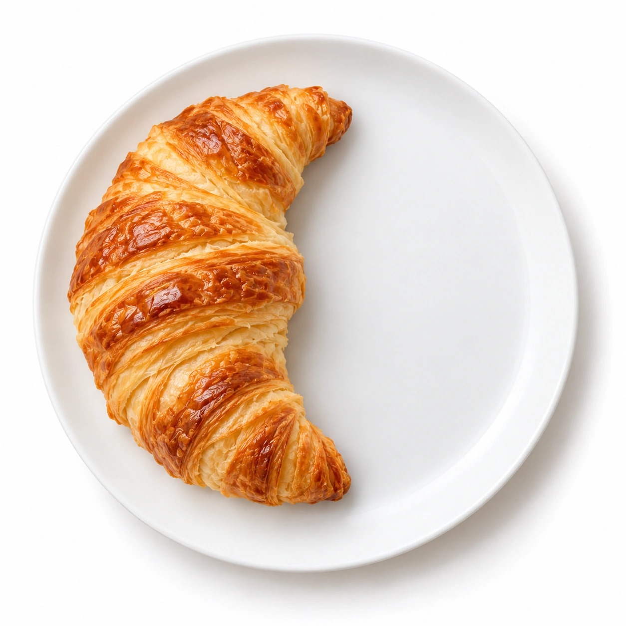 Croissant auf einem weißen Teller.