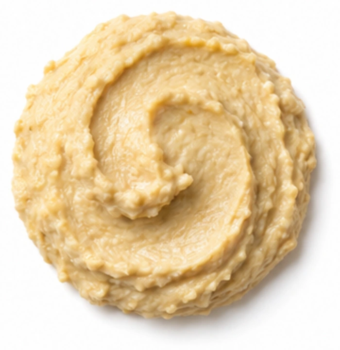Hummus vor weißem Hintergrund.